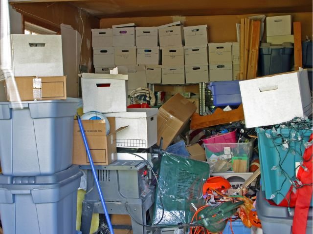 Garage cluttered with boes and stuff.