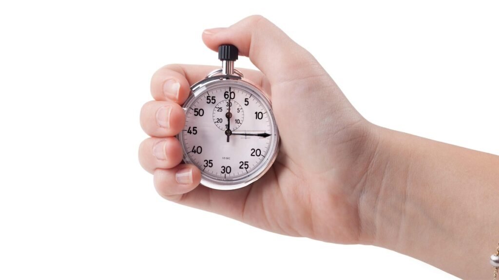 A hand holding a stopwatch to represent a fast and focused 15-minute decluttering session.